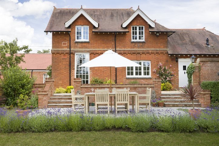 Landscaped garden and patio beside a brick house